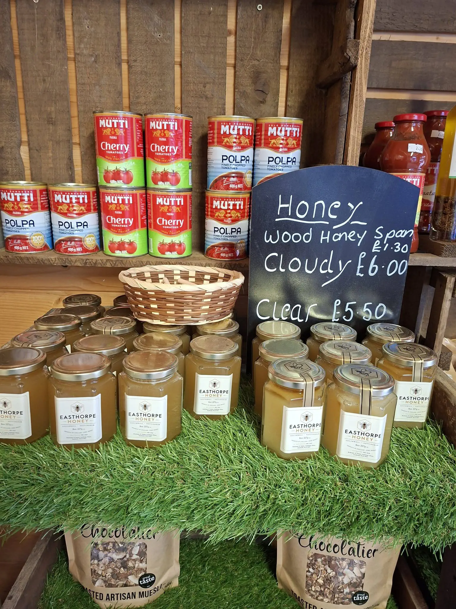 Jars of Easthorpe honey from Southwell, with tins on the shelf behind.